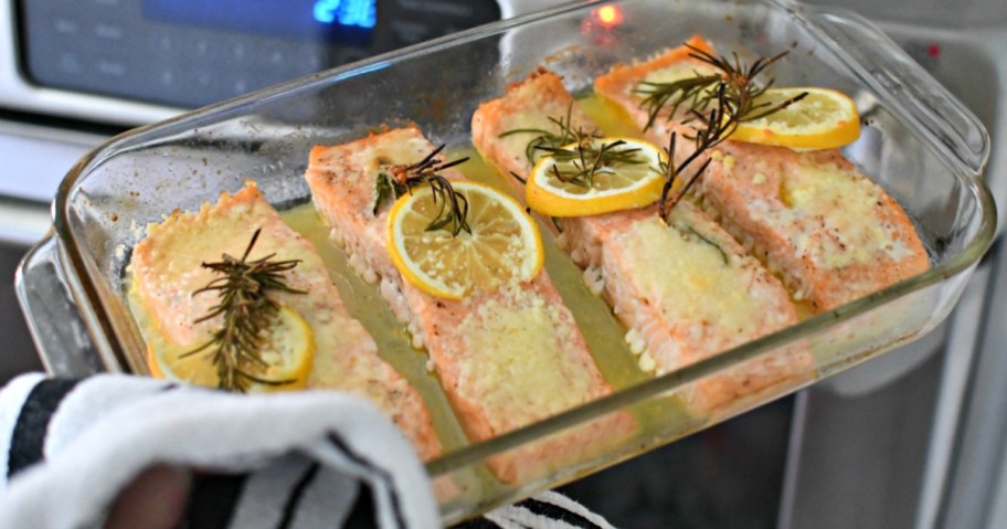 glass dish with baked salmon in oven