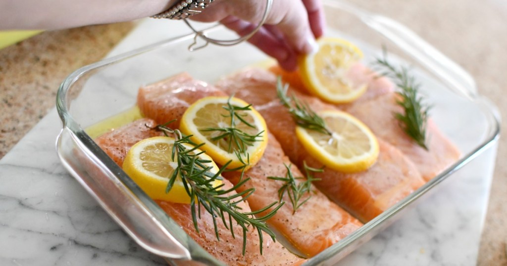 putting lemon slices on salmon