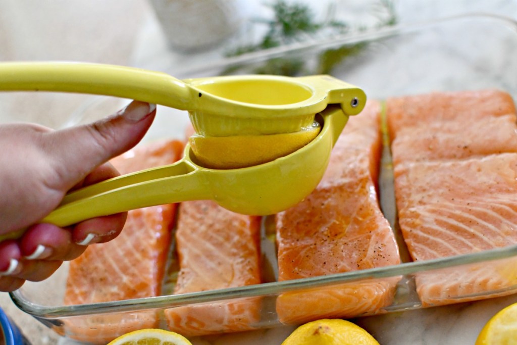 squeezing lemon over salmon