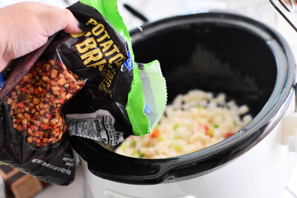 Adding frozen potatoes to slow cooker to cook soup. 