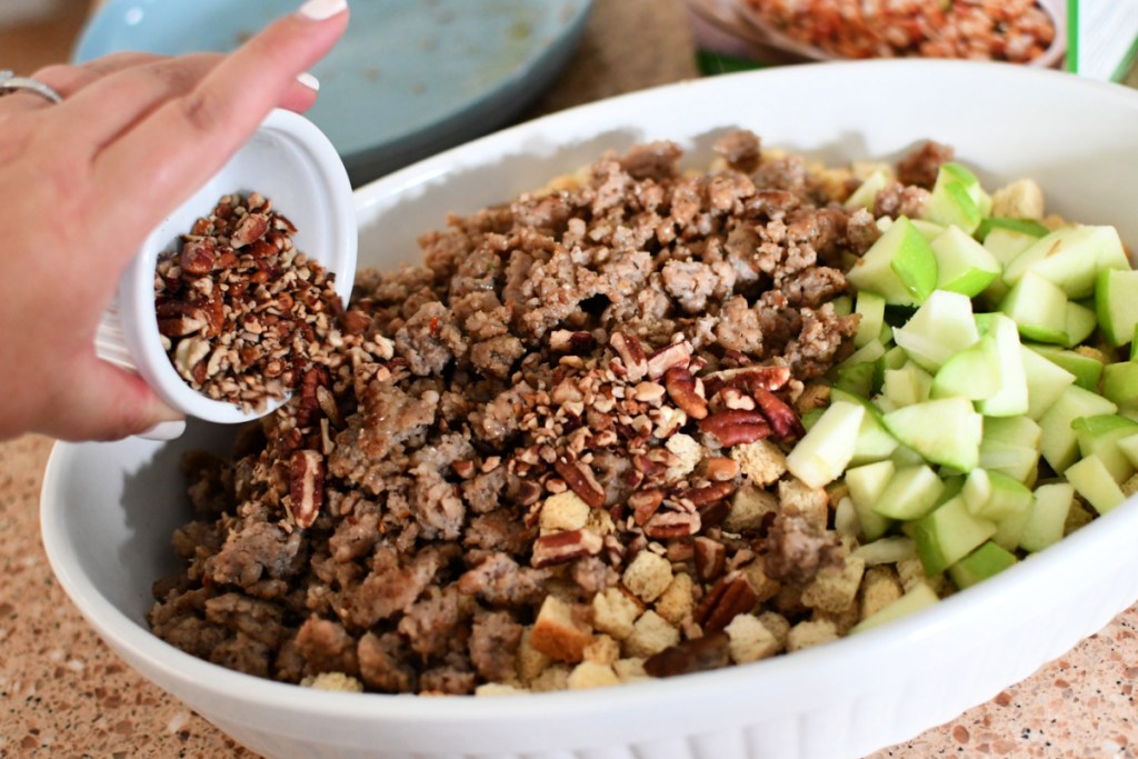 pouring pecans into stuffing