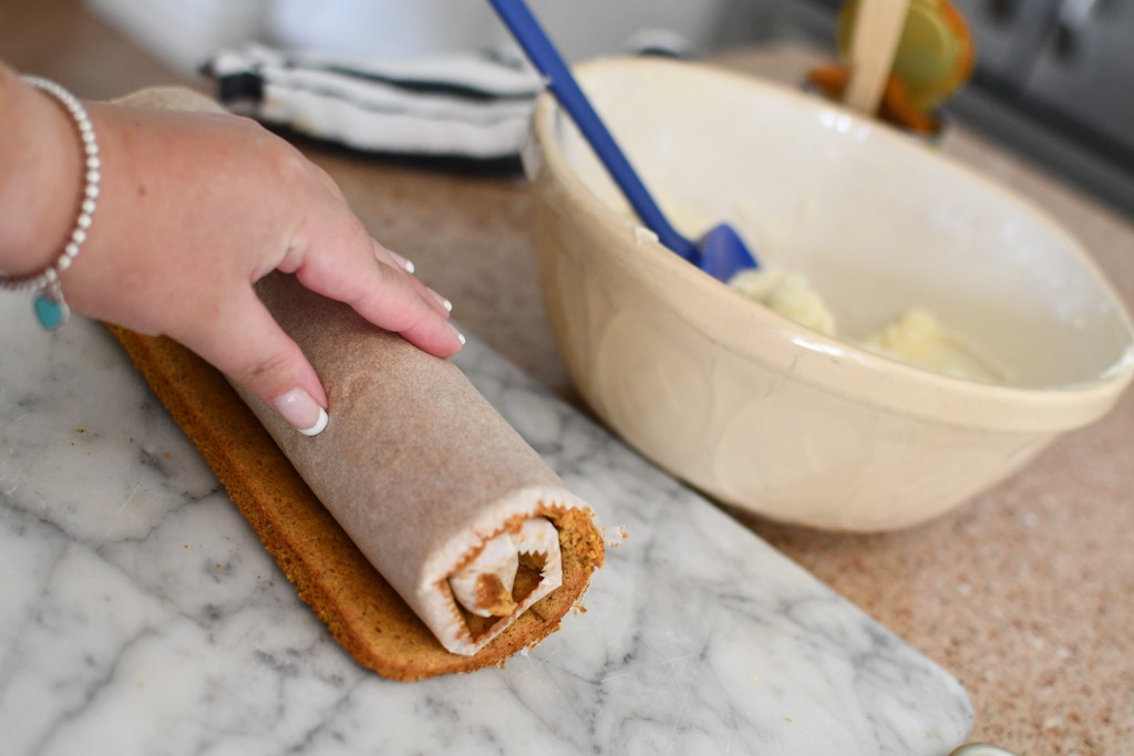 fully rolled up pumpkin roll in parchment paper 