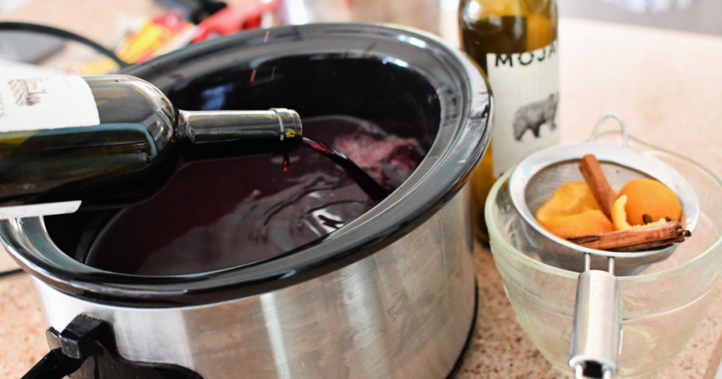 pouring red wine in a slow cooker for mulled wine