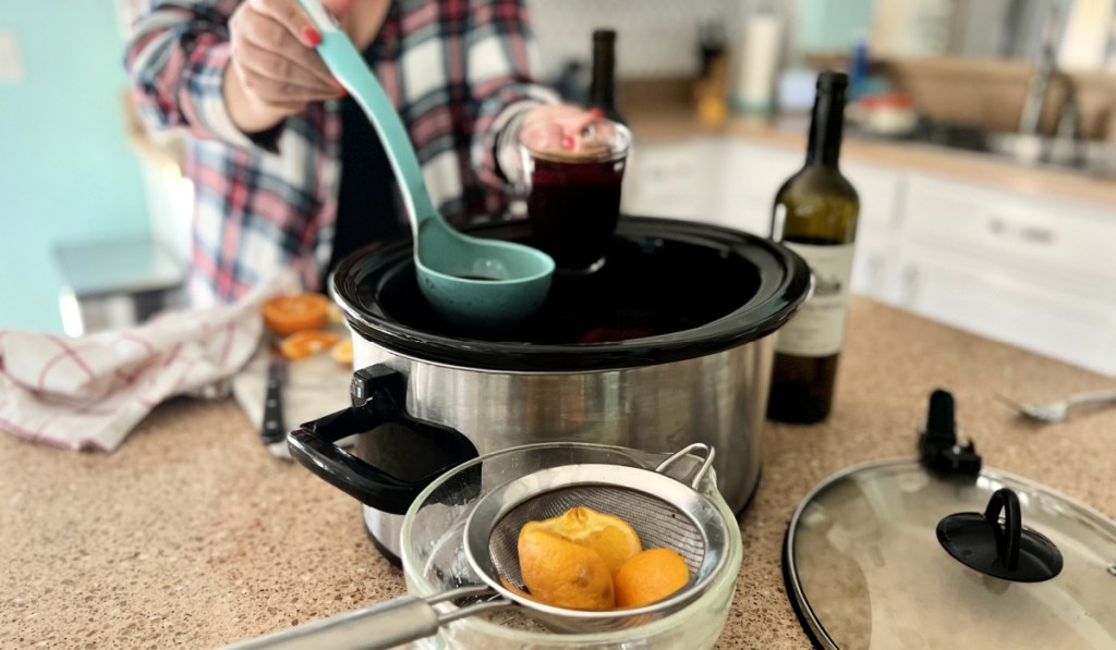 woman dishing up mulled wine slow cooker 