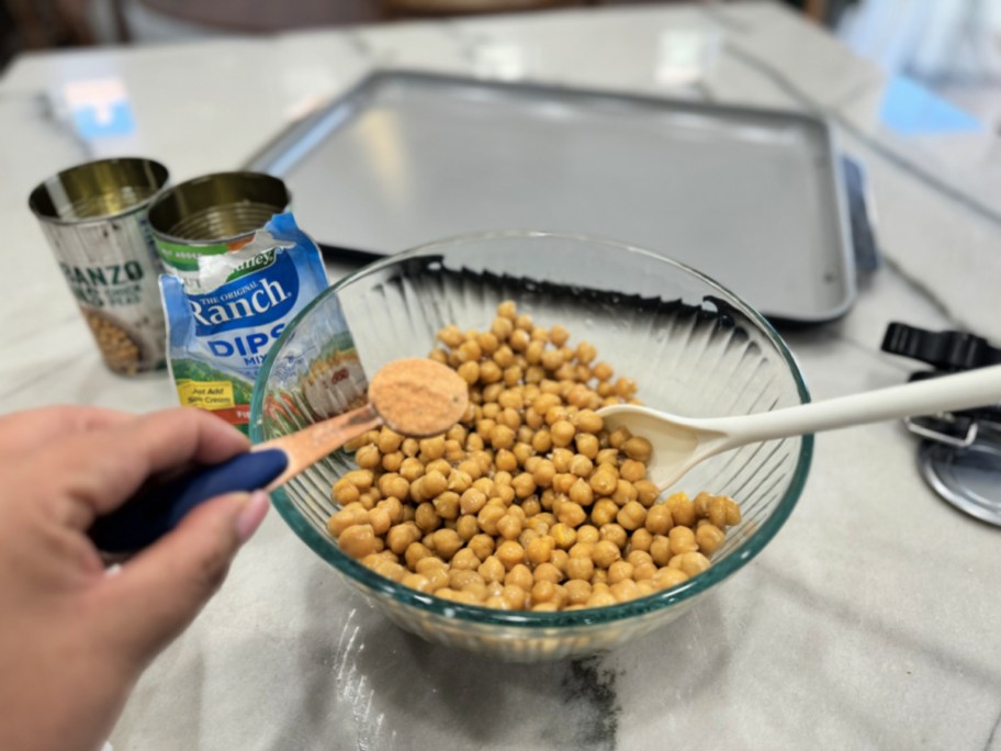 adding fiesta ranch seasoning to bowl with canned chickpeas