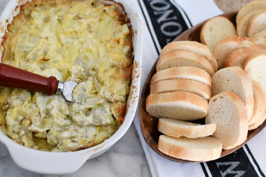 melted cheese artichoke dip in a casserole dish