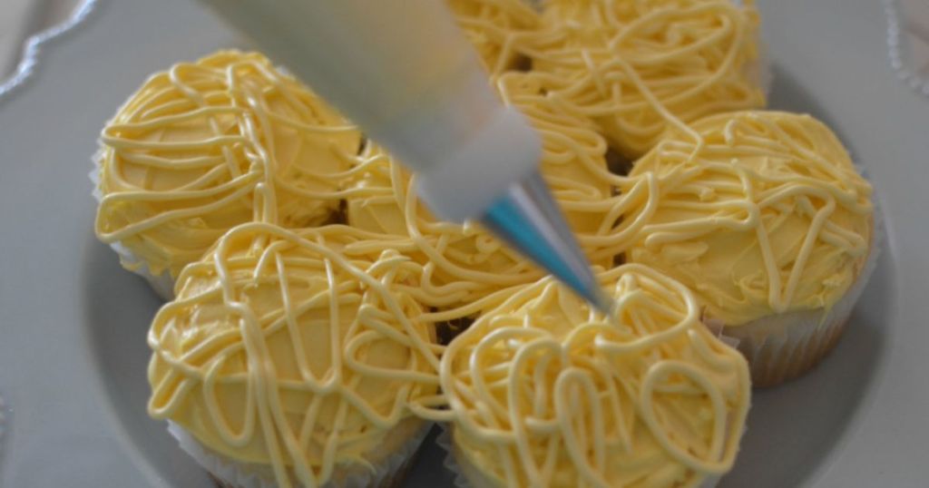 piping frosting on april fools spaghetti and meatball cupcakes