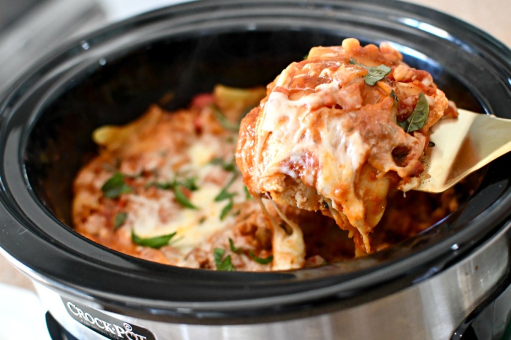 lasagna being spooned from slow cooker