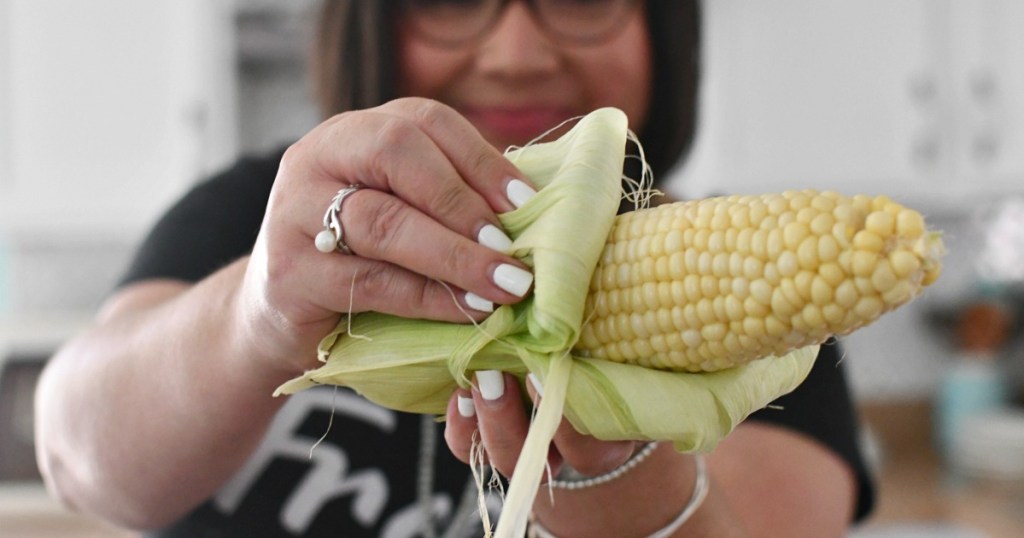 woman pulling back corn husk 