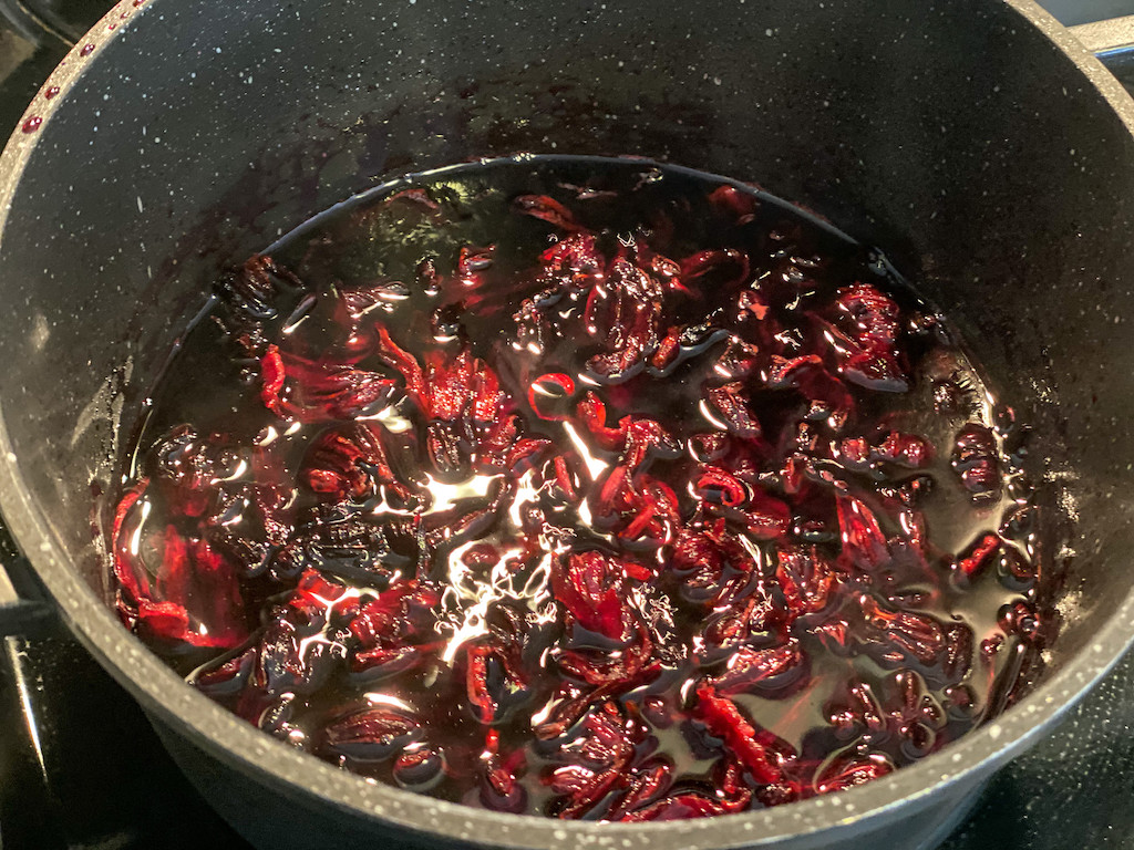 dried hibiscus flowers in pot with water and sugar 