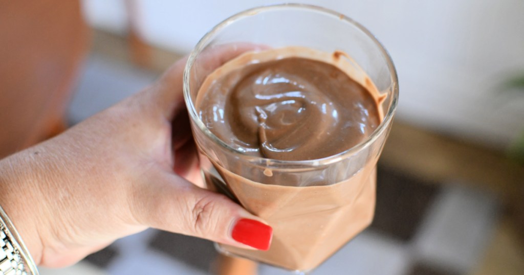 holding a cup with chocolate avocado smoothie