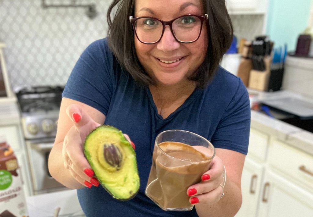 woman holding a chocolate avocado smoothie