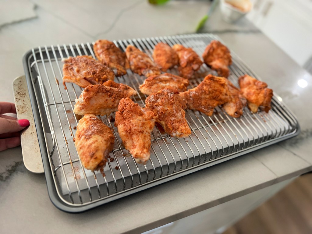 raw seasoning chicken wings on a baking tray