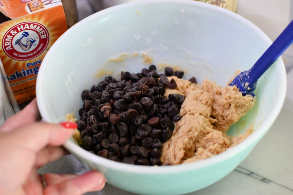 adding chocolate chips to bowl with batter