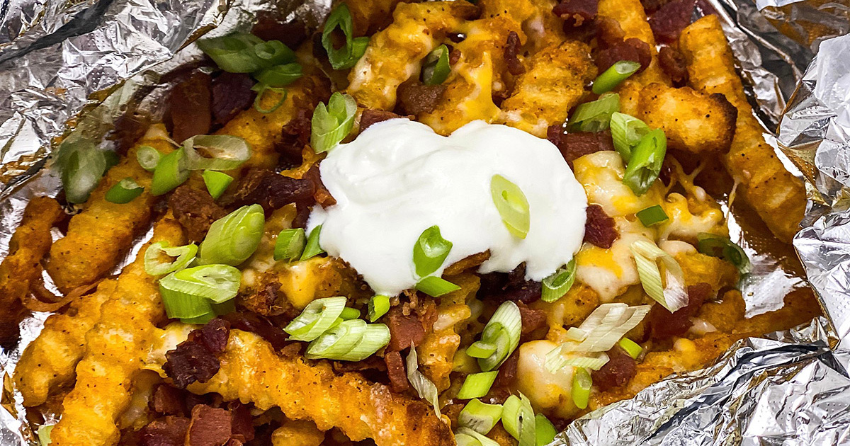 dollop of sour cream on top of loaded grilling fries