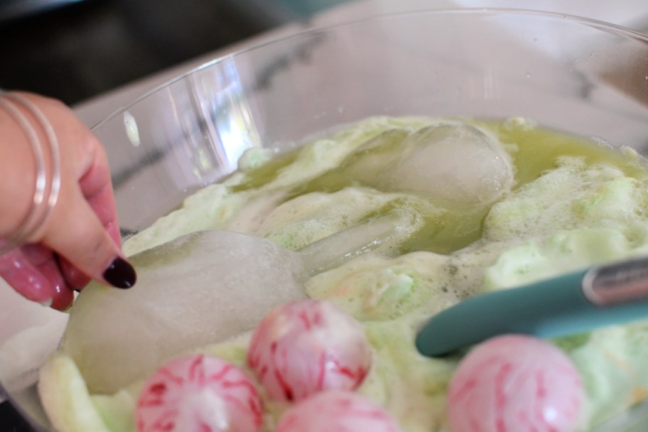 adding hand ice cubes to halloween party beverage