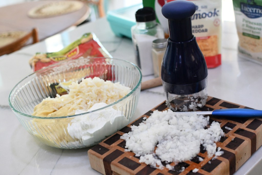 adding-finely-diced-onion-to-casserole- عش قليلاً واخبز البطاطس الجنائزية اللذيذة!