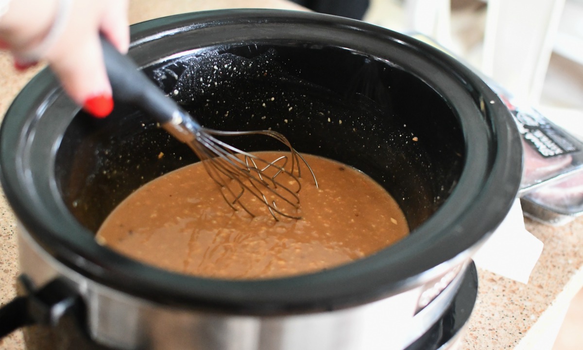 stirring gravy mixture in slow cooker