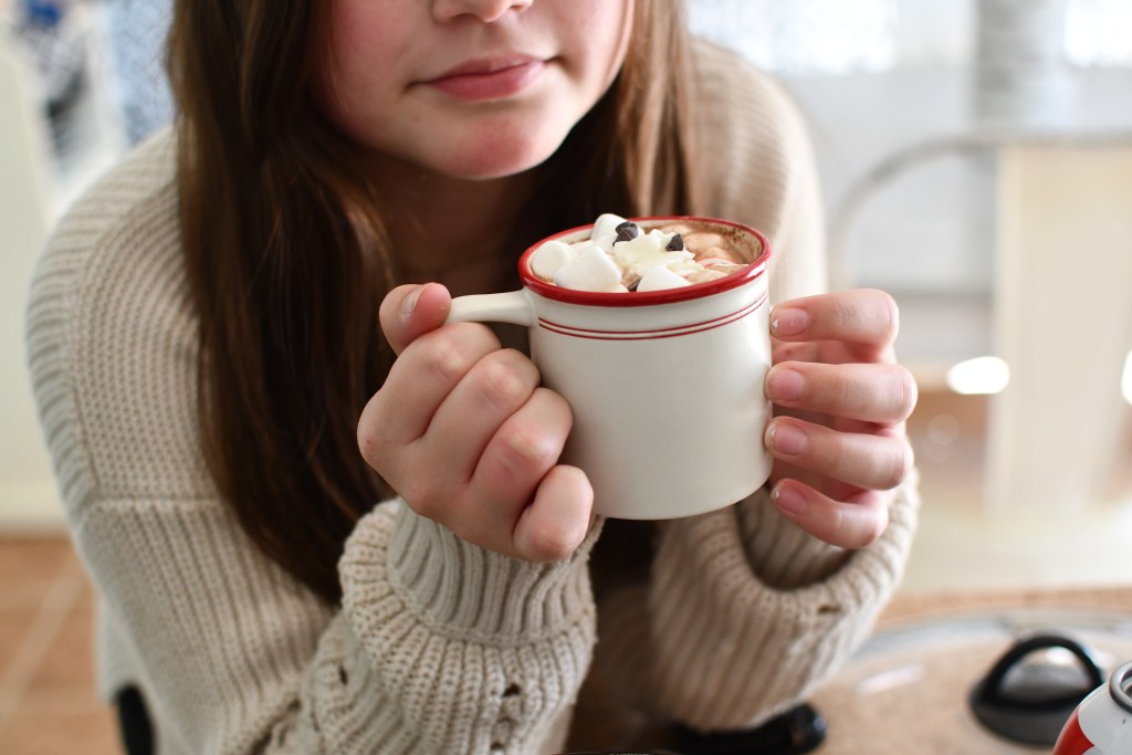 holding a mug with crock pot hot chocolate