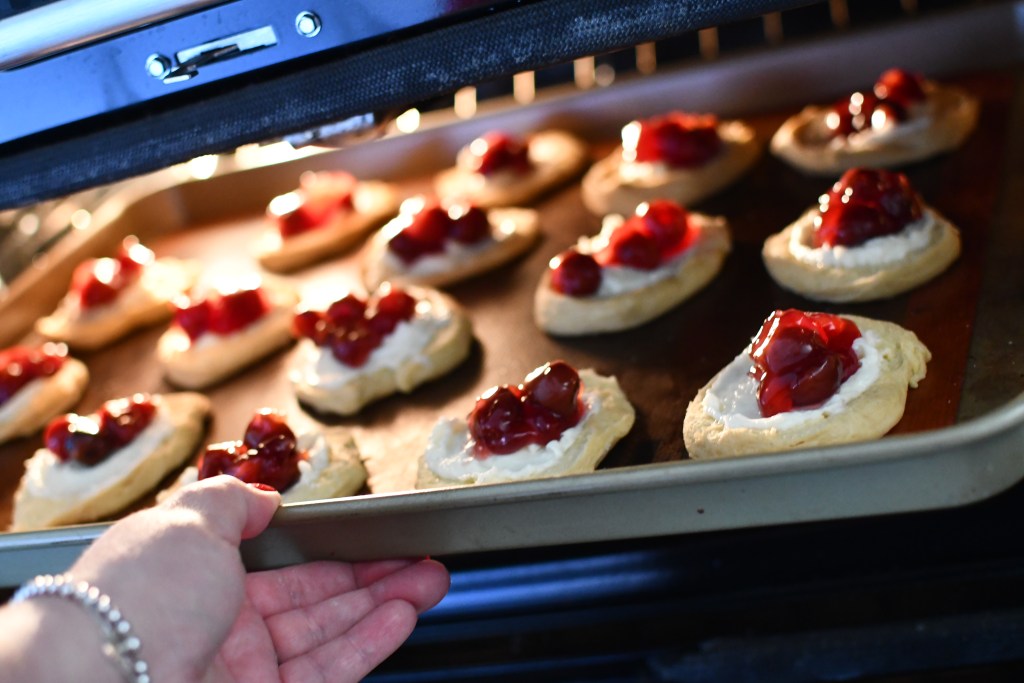 placing cherry cheese danish in the oven