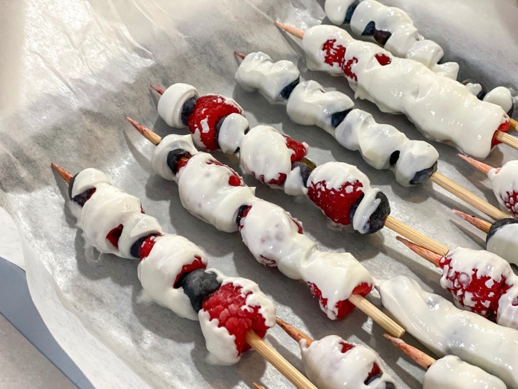 casserole dish with yogurt covered berries on skewers