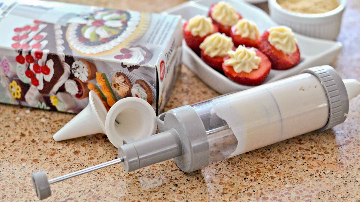 wilton cake decorating tool with strawberries on counter