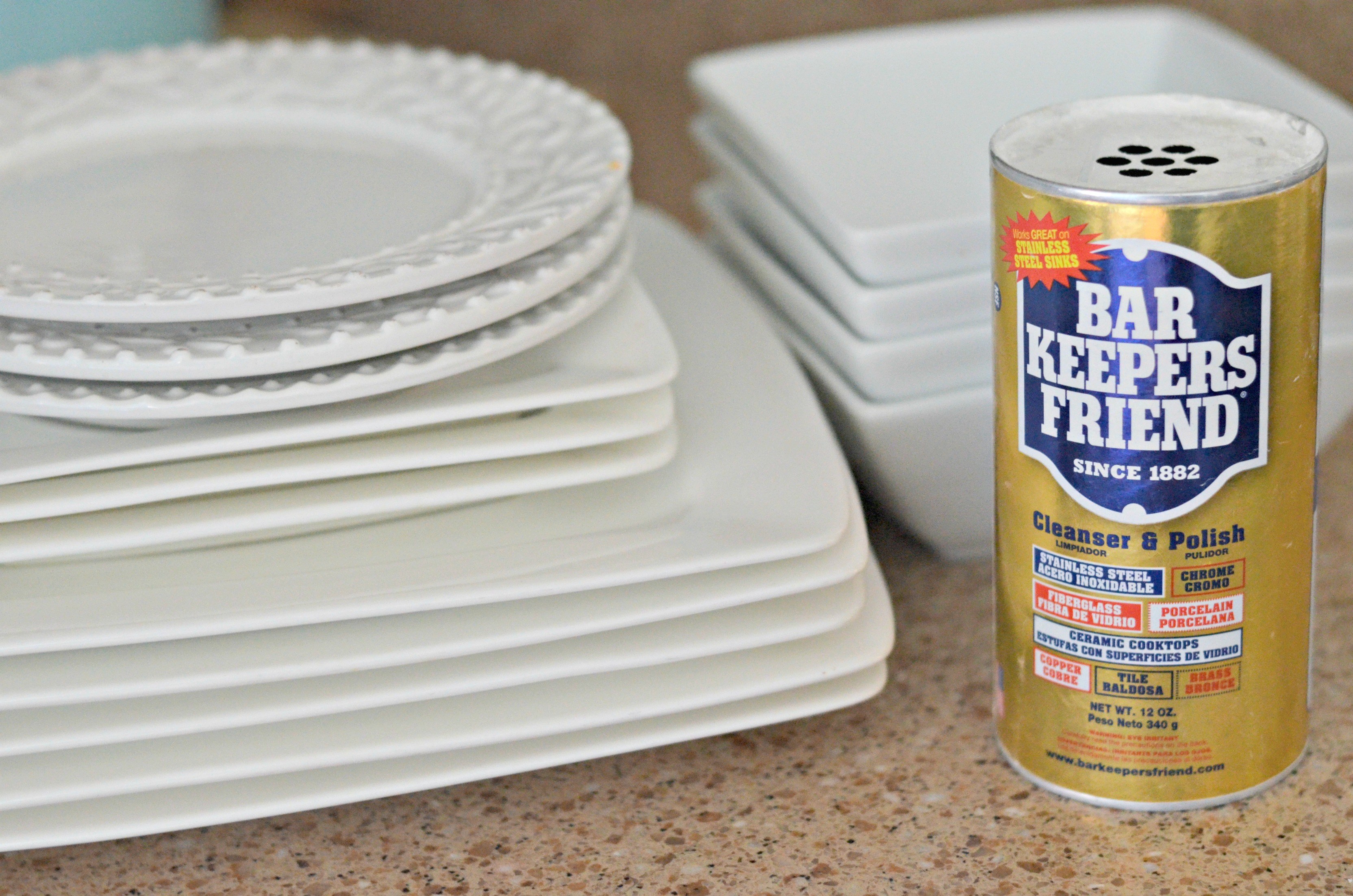 Bar Keepers Friend next to a stack of dishes