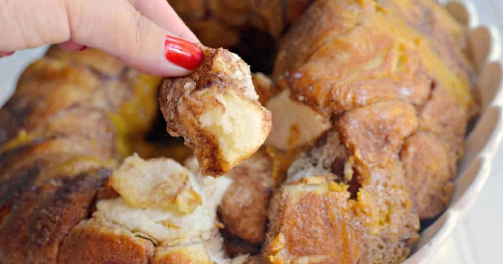 hand pulling out piece of pumpkin cheesecake monkey bread