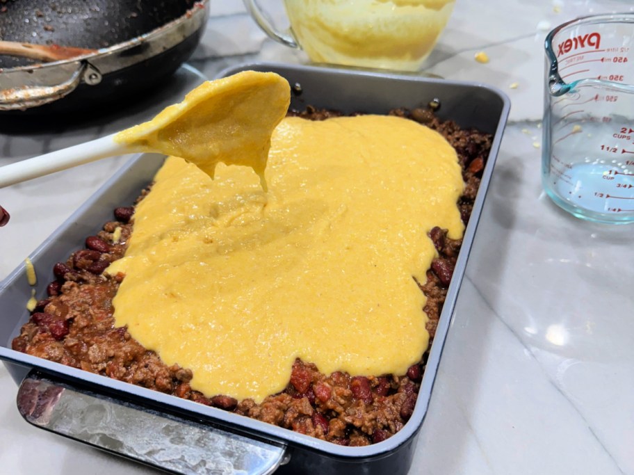 adding cornbread batter to chili 