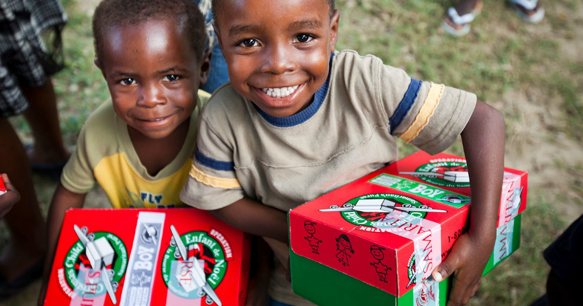 Operation Christmas Child Boxes. Two kids, each holding a box.