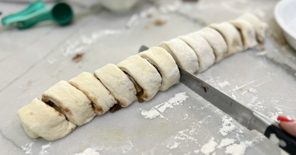 cutting up cinnamon rolls