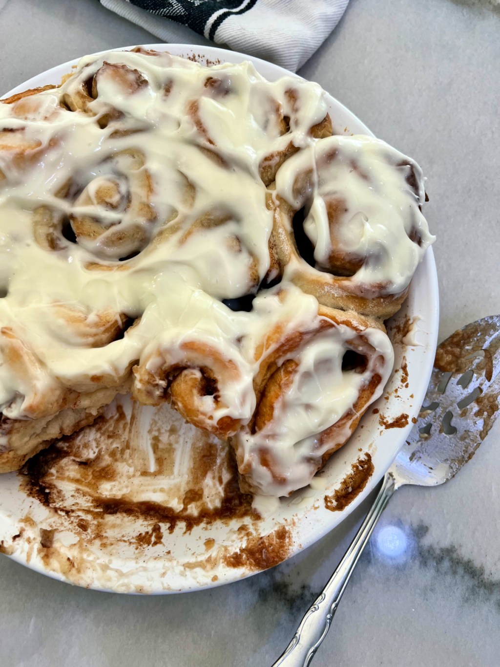 pan of cinnamon rolls with frosting in the counter