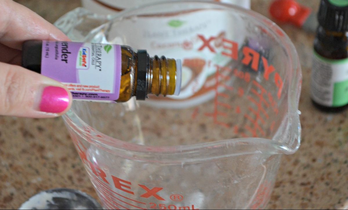 lavendar oil being poured into measuring cup