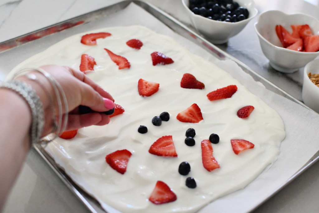 adding berries to yogurt bark