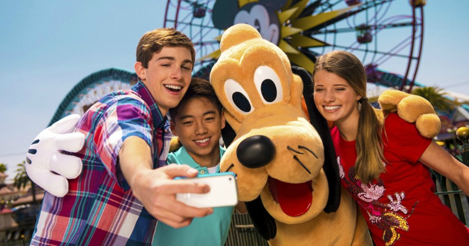 disneyland visitors taking a photo with pluto