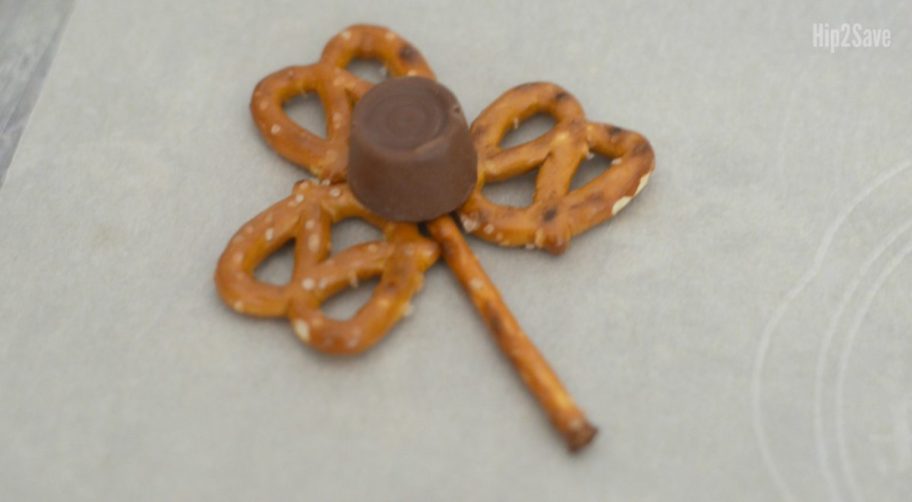 putting rolo on top of pretzels in order to make St. Patrick's day snacks