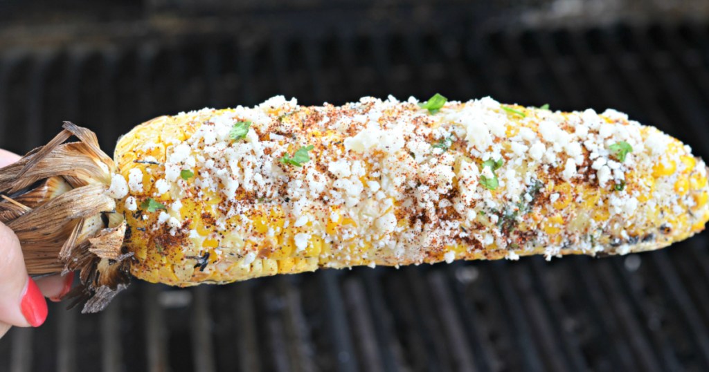 woman holding mexican grilled corn