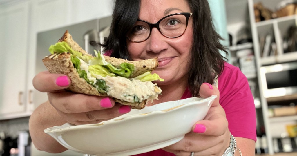 woman holding a chicken salad sandwich