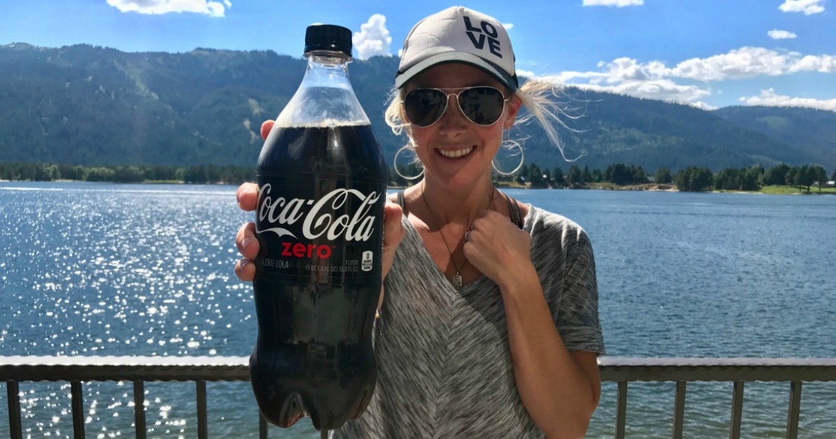 Collin holding a bottle of Coca-Cola Zero in front of a lake