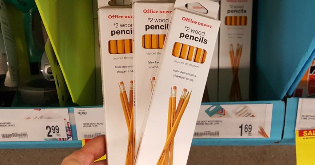 ręka trzymająca pudełka z ołówkami w sklepie