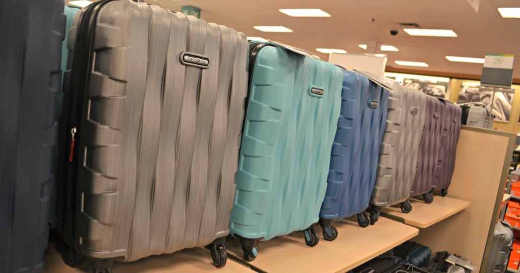 various colors of Samsonite hardside spinner luggage carry on size on display in store on shelf 