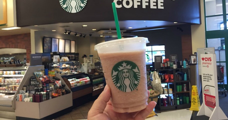woman holding Starbucks cup in front of a Starbucks store in Target