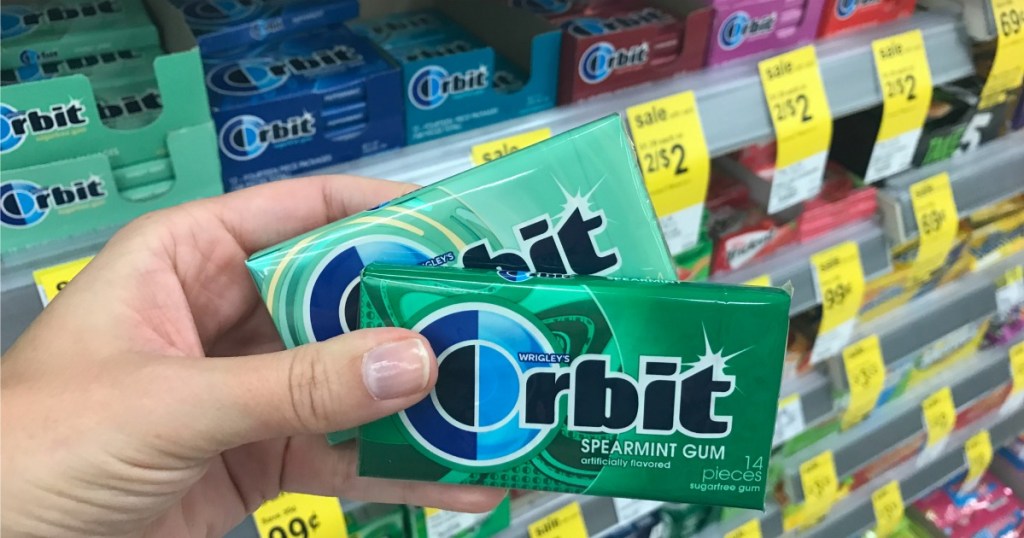hand holding packs of gum in a store