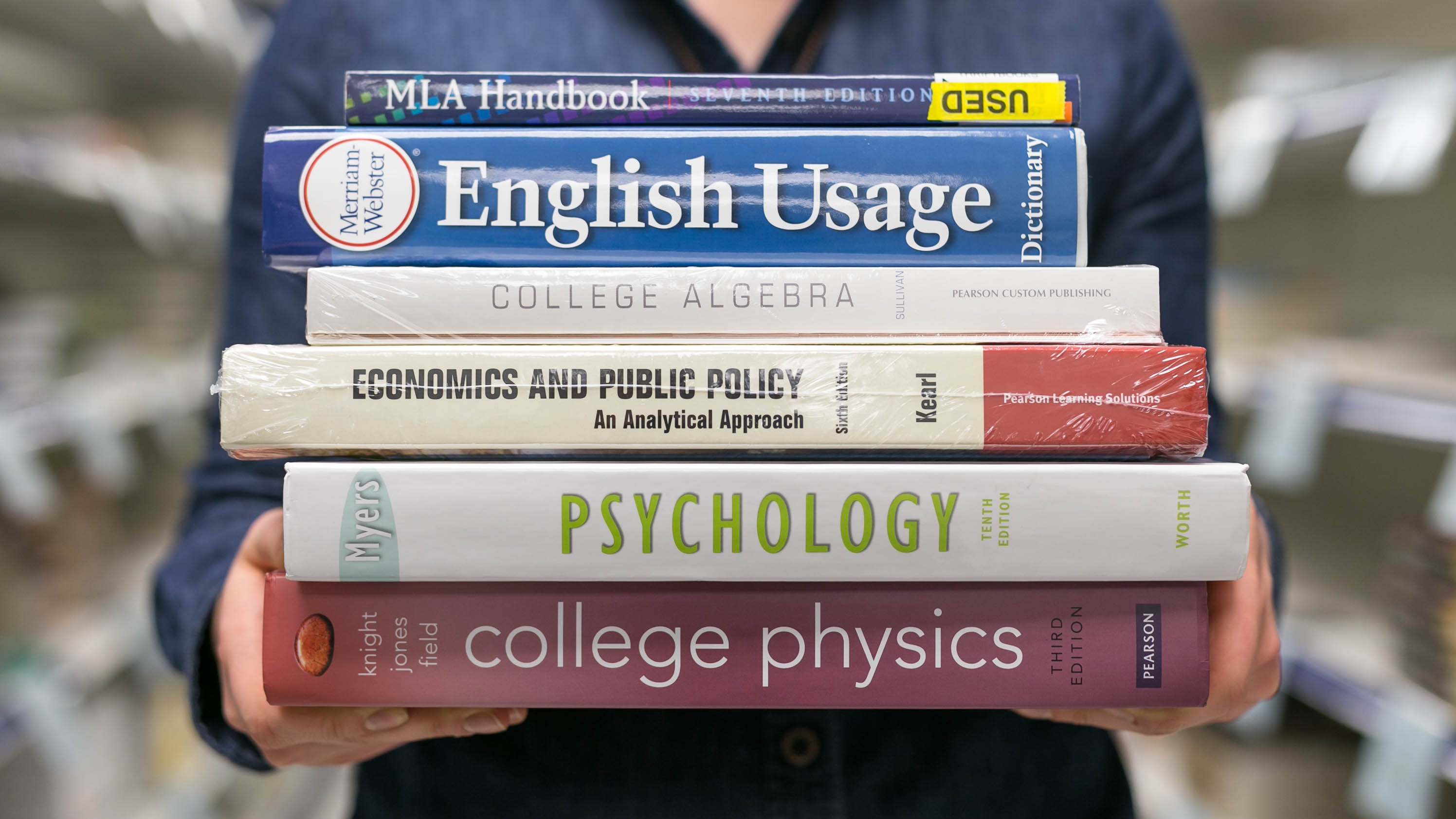 back-to-school deals at office depot, walgreens, walmart, and more – student holding a stack of textbooks