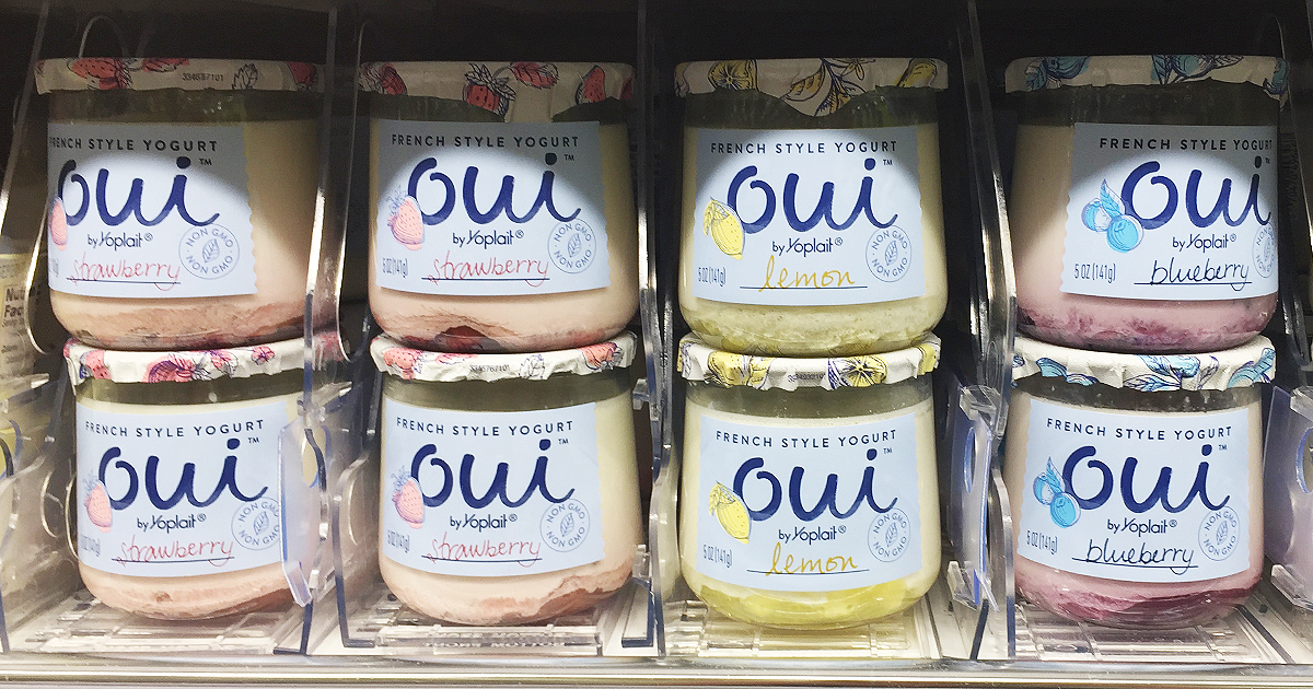 glass jars of oui yogurt stacked two high and lined up on a store shelf