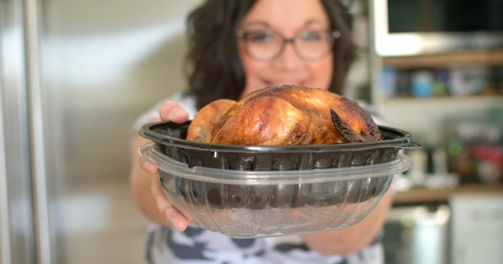 woman holding a rotisserie chicken