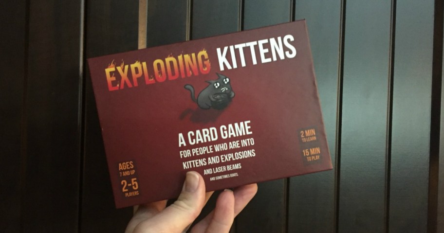 hand holding exploding kittens party pack game