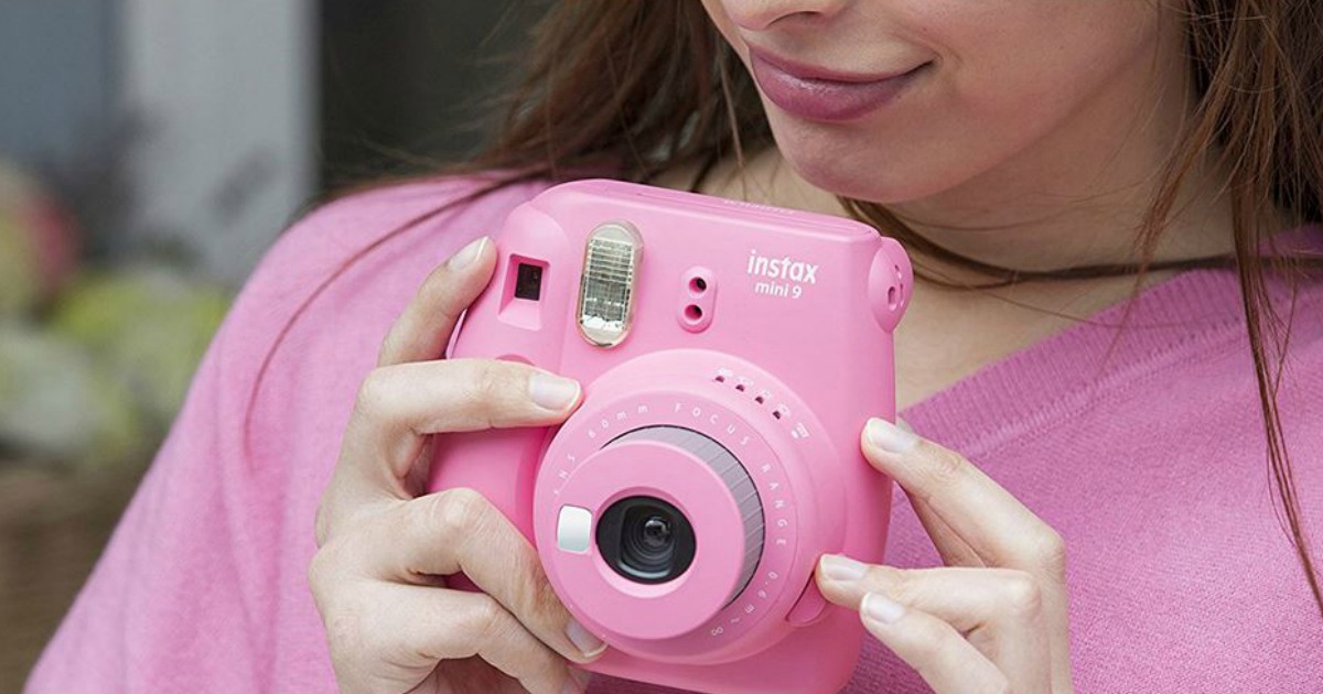 woman using pink Fugi Instax camera