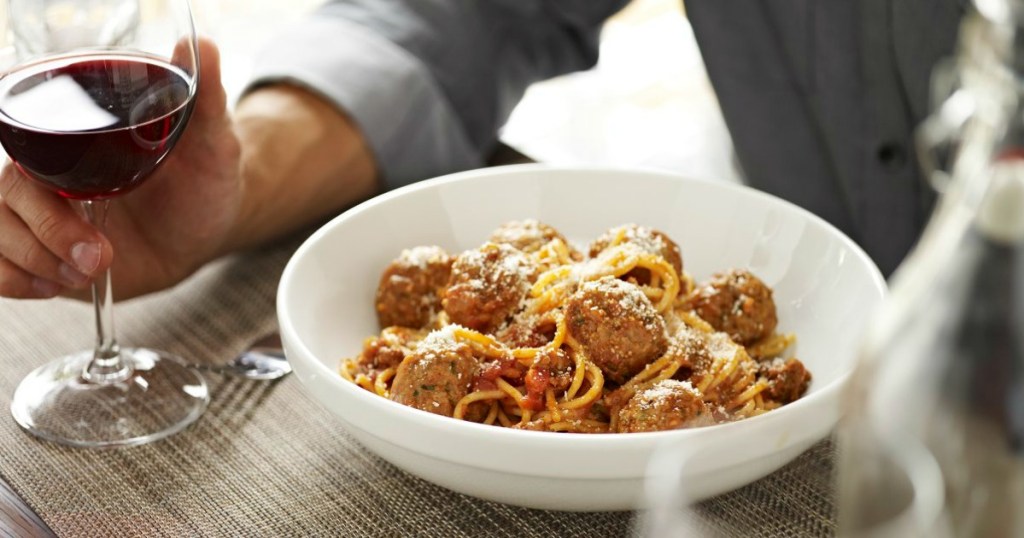 person eating a bowl of spaghetti and meatballs