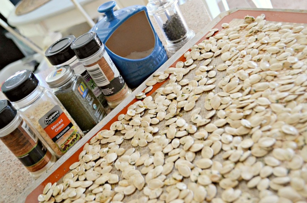pumpkin seeds on tray next to seasonings